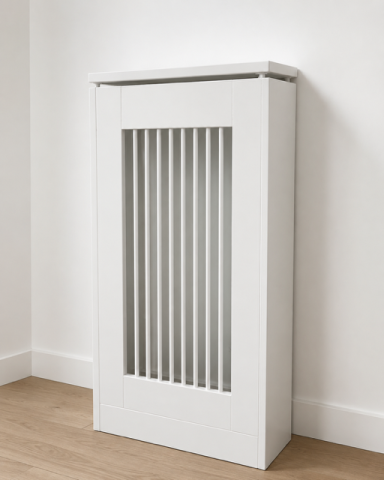 Radiador blanco con rejilla vertical en una pared clara, sobre suelo de madera.